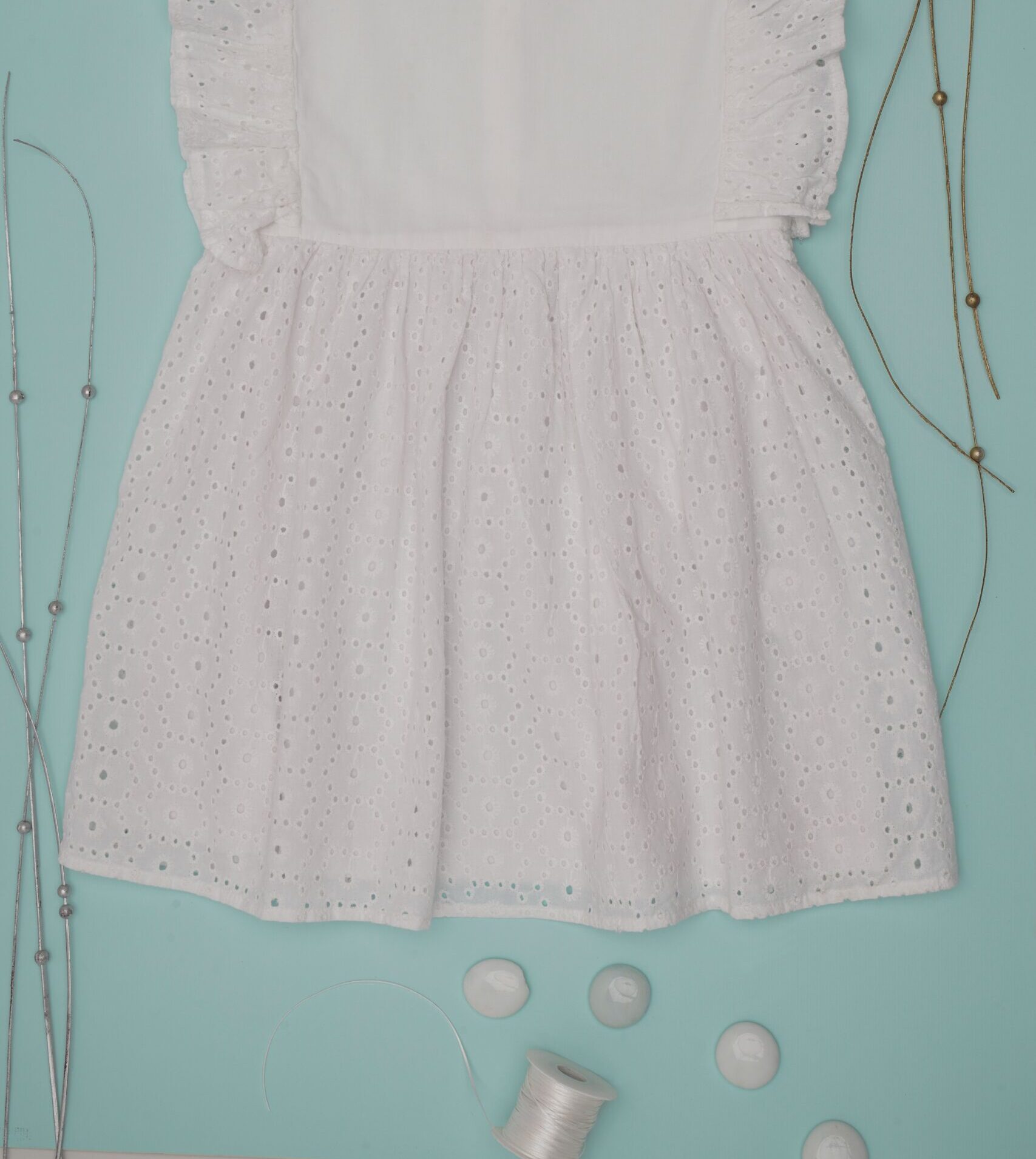 Charming white baby dress with lace details, perfect for special occasions.